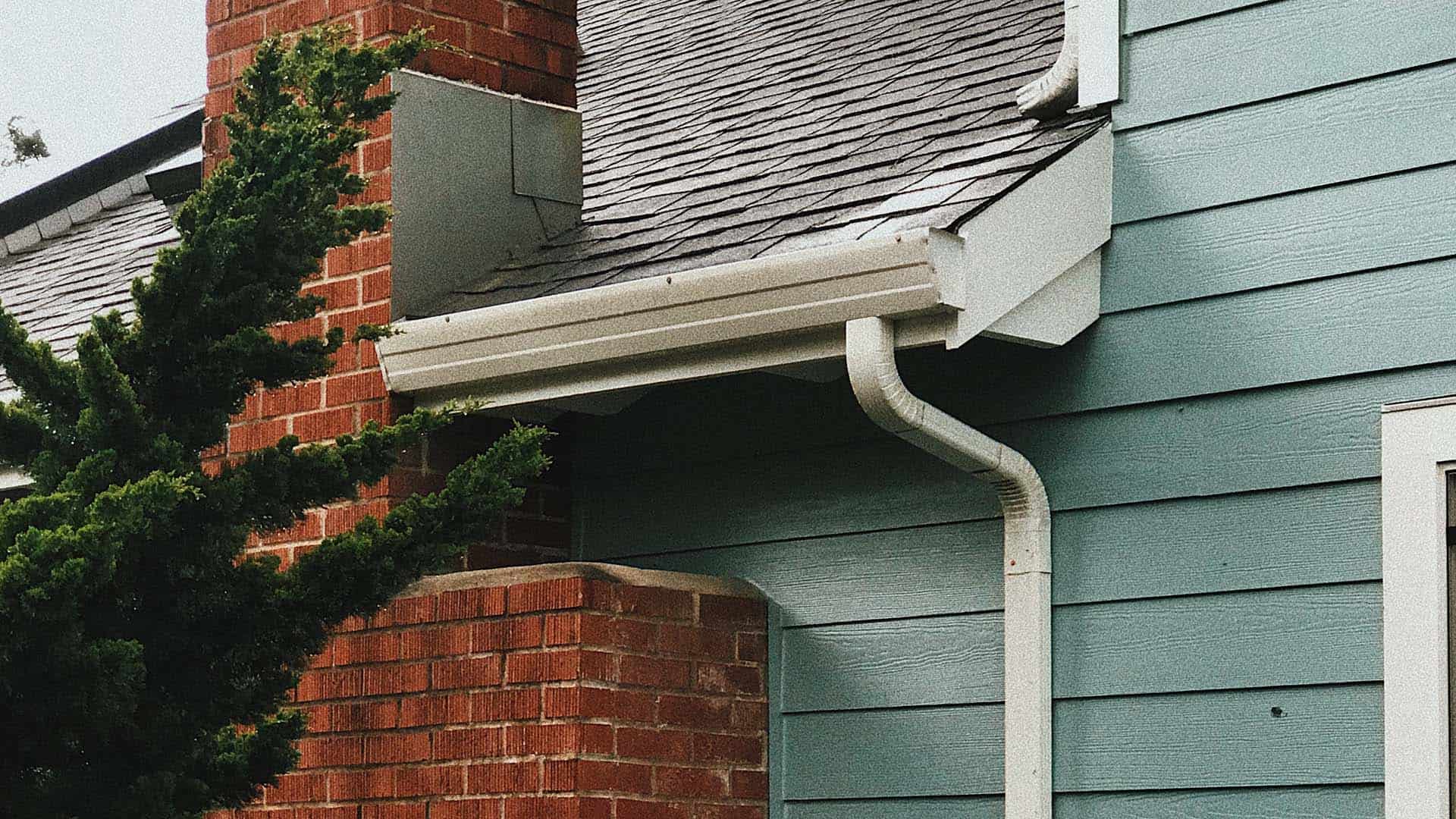 cropped image of minneapolis home's gutter, downspout, and roof edge