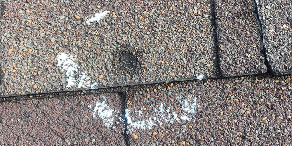 Close up of a shingle with hail damage on a Minneapolis home