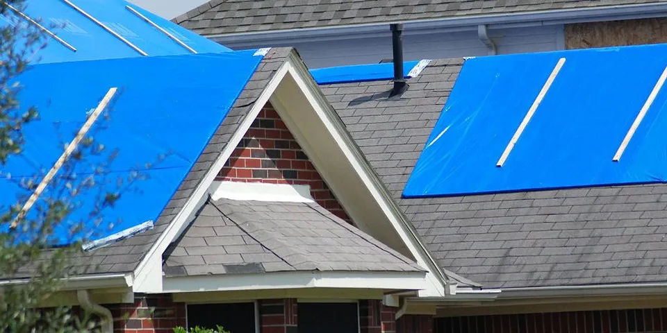 A Minneapolis house with tarp on its roof to prevent further leakage 
