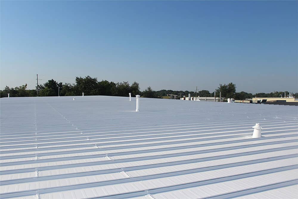 New coating on commercial roof in Minneapolis, white coating under a blue sky