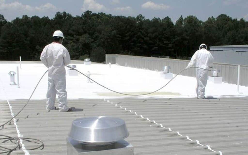 Commercial roof coating being applied by two roofing contractors in Minneapolis