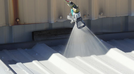 Spray commercial roof coating being applied on a commercial building roof in Minneapolis