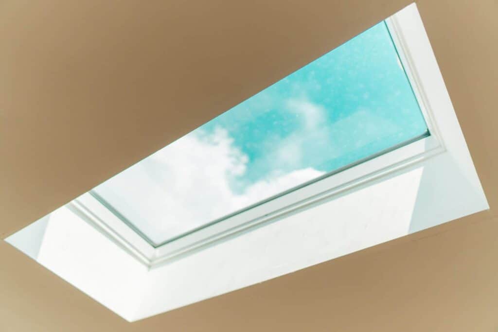 Cropped image of skylight in St. Paul home after a roof replacement, showing a blue sky with clouds