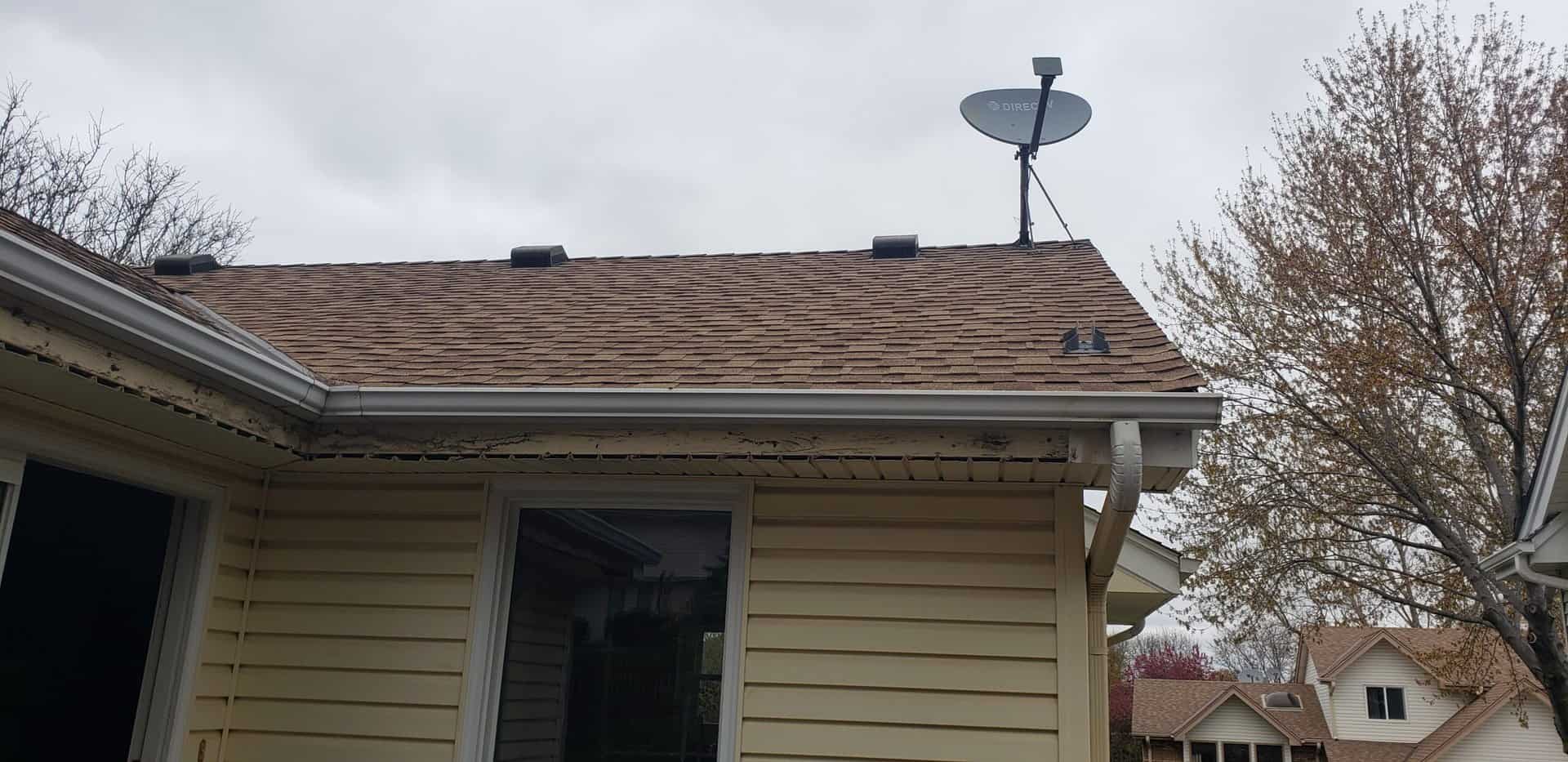 corner of a yellow house with new gutters from a Minneapolis roofing company