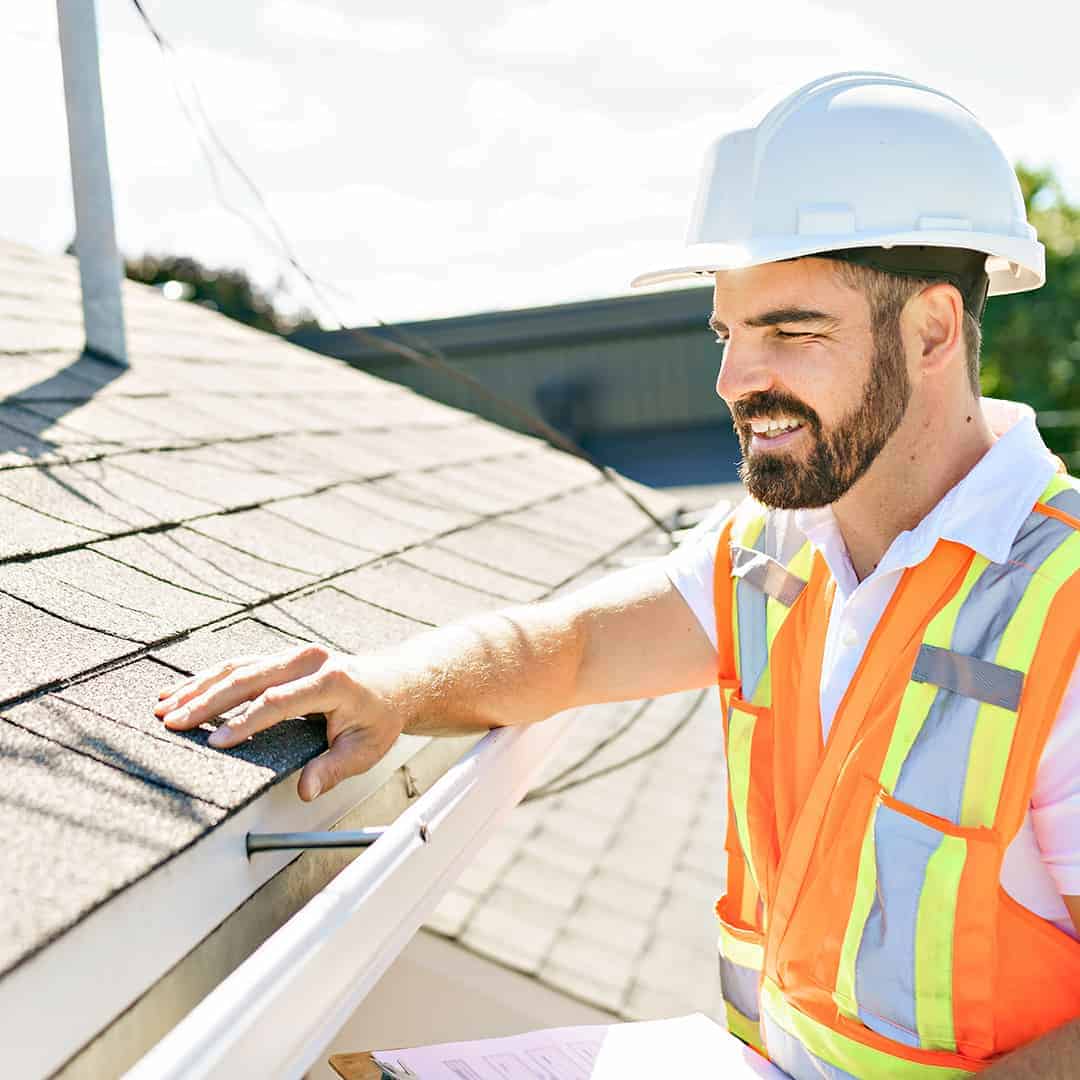 Roofer in safety gear inspecting a Minneapolis Roof